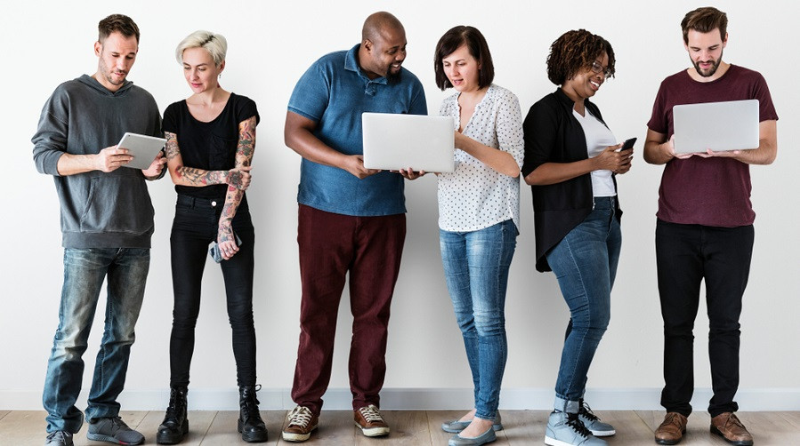 Diverse people looking at computer screens and talking
